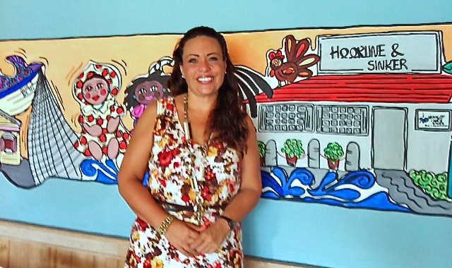 Erika Romo painted the brightly colored mural that decorates the room at Hook, Line and Sinker.