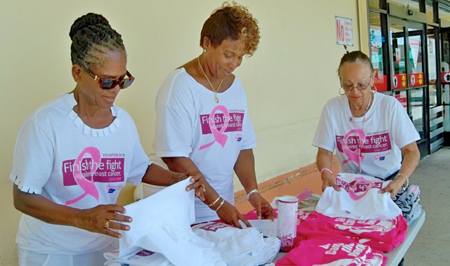 From left ACS volunteer Martha Mills, walk chairwoman Vivian Furet, and co-chairwoman Lucy Rodriguez fold T-shirts shirts. 