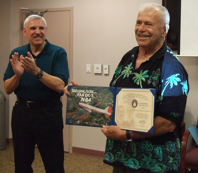 Abel Mirabel, from the FAA, joins the applause for Nicholas Castruccio Wednesday after he was presented with the Master Pilot Award.