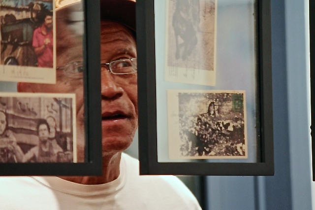 A man peers at Clay Jones' installation, 'Two Sides of the Same Coin.'