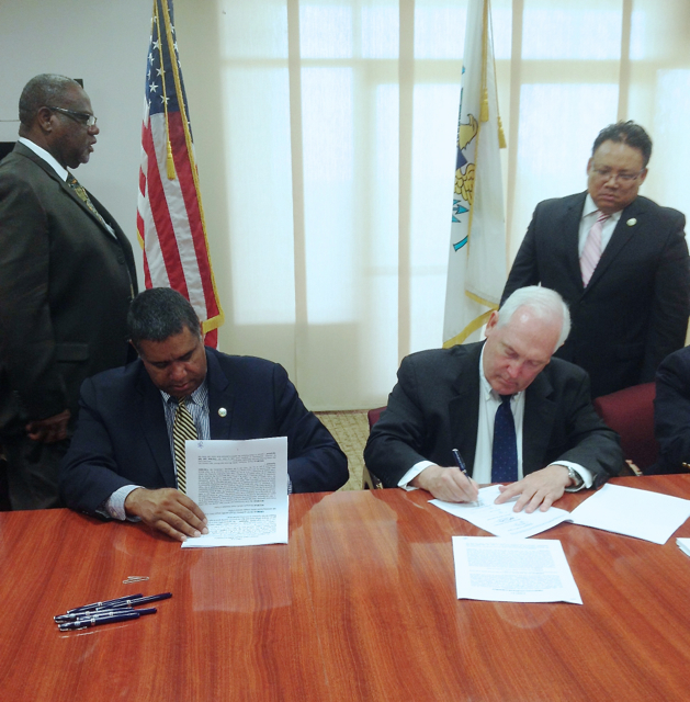 Gov. John deJongh Jr. and Robert Moore, chief executive officer of Atlantic Basin Refining VI, sign an operating agreement Wednesday that, if approved by the Senate, will allow the company to begin the process of restarting the St. Croix oil refinery. Witnessing the signing are V.I. Attorney General Vincent Frazer, left, and Government House senior policy advisor Richard T. Evangelista.