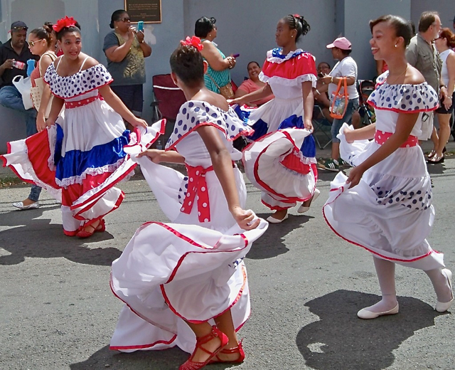 Dancers from Ballet Folklorico Domincano swirl down the street.