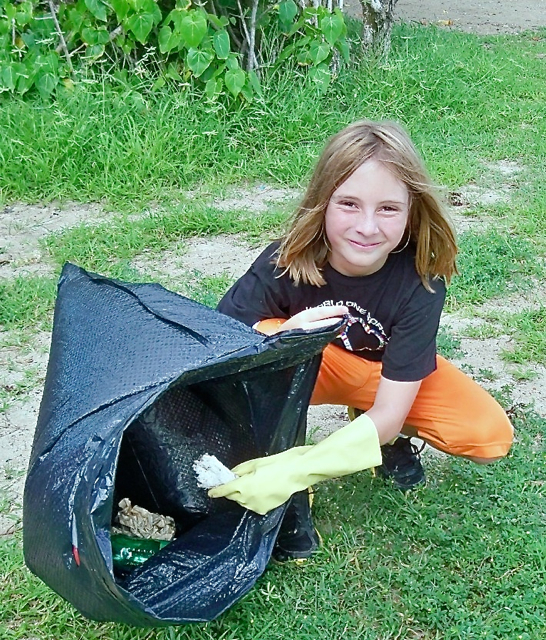 Parker Younger, a 10-year-old student at Good Hope Country Day School, picks up trash.
