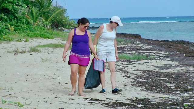 Amanda Beach and Kathleen Adams, teachers at GHCD, scour the shore for trash.