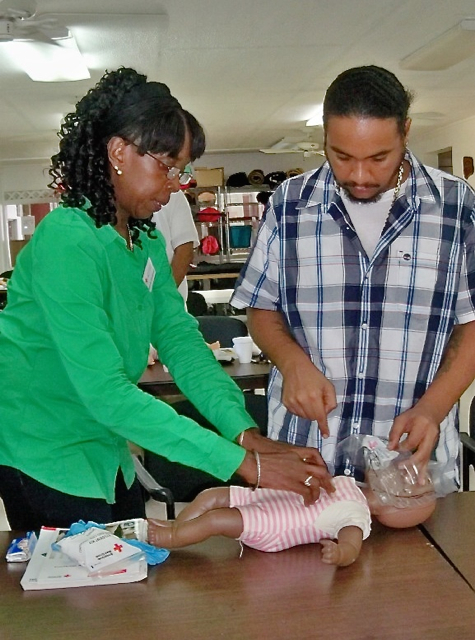 Marjorie Emanuel and Perry Levons practice CPR for infants.
