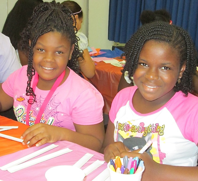 Raynesha Noel, 10, and Alexis Doway, 11, make bracelets at the Summer Reading Challenge celebration.