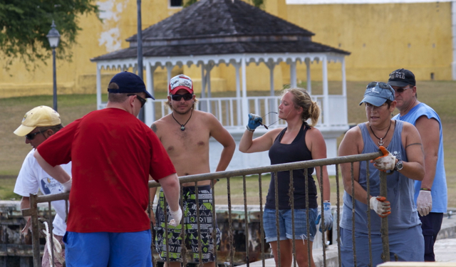 Volunteers wrestle a traffic control gate found in the harbor.