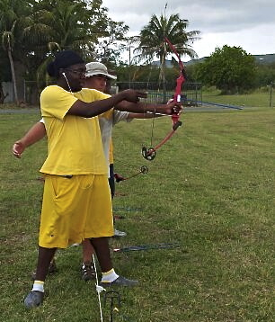 WIlliam Cole shows Akeem Phillips how to use a bow and arrow.