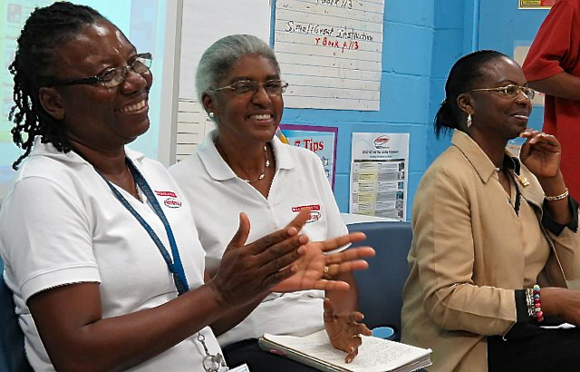 READ 180 instructors Andrea Ryan and Beverly Hendricks, along with CAHS principal Carmen Howell, applaud student speakers during Friday's ceremony.