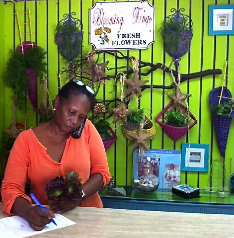 Lorna Webster takes a phone call at the counter of her event planning business, Blooming Things.'