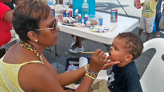 Alyssa Fredericks paints the face of 2-year -old Gion Richardson.