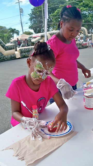 Six-year-old Amaya Luke, seated, and Laurnelle Gordon, 11, decorate cupcakes.