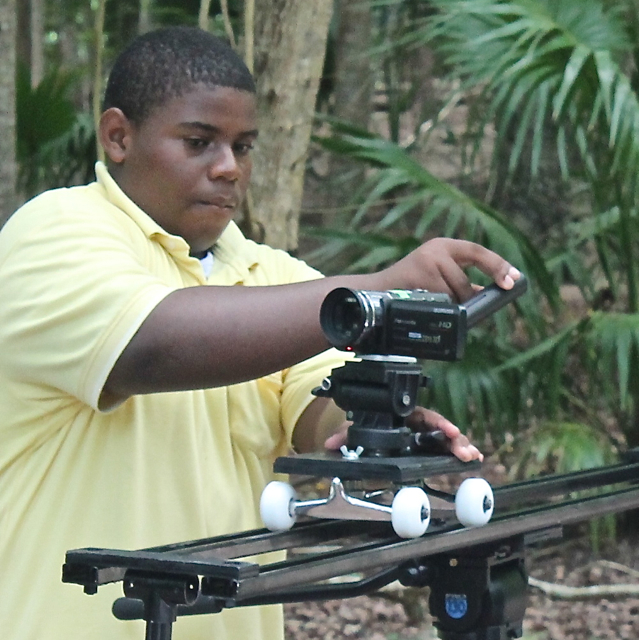 YMW student Michael D. Brown of Wesleyan Academy rigs the camera on a dolly dolly for a tracking shot. (Jae Knight photo)