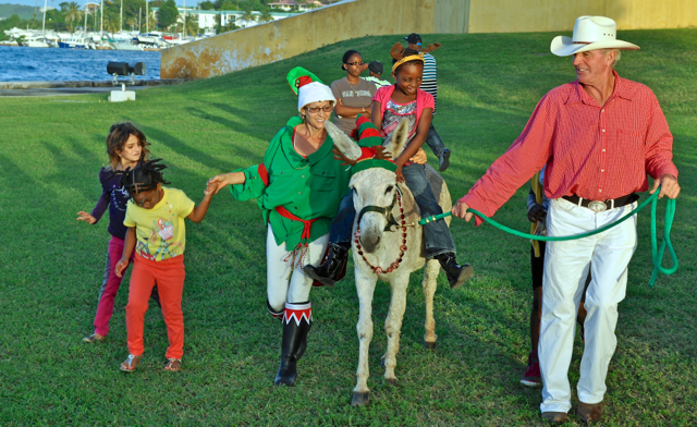 Steven O’Bea leads Donkey Howdy and her passenger on a 'Crucian reindeer ride' as part of Saturday’s activities.