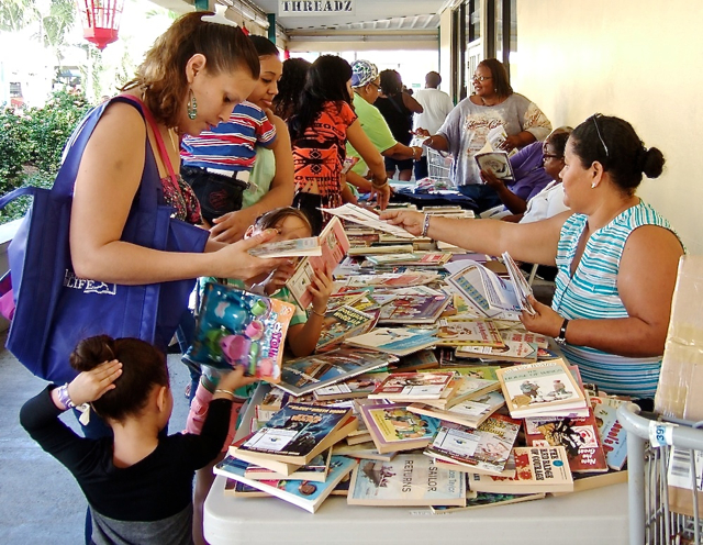 Families sort through free books being offered Saturday at the Sunny Isle Shopping Center.