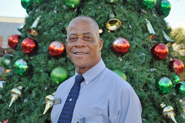 Mario Hendricks Sr. stands in front of the Christmas tree at Sunny Isles Shopping Center.