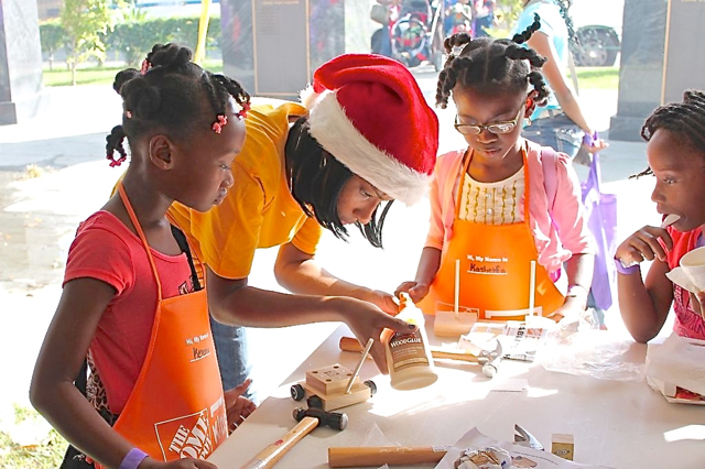 'Santa Helpers' lend a hand as youngsters build toys in the Home Depot Kids' Workshop section.