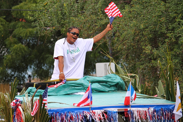 A reveler waves the American flag from the back of a float.