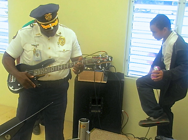 Acting Police Chief James Parris tries out a bass guitar at the PAL Center in Frederiksted and finds he's "still got it.'