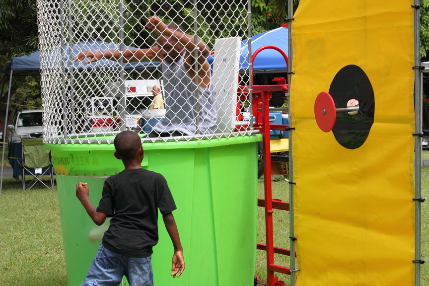 A boy nails the dunk tank bullseye and sends Lee Seward into the drink.
