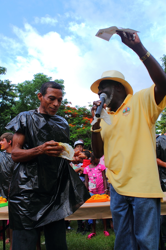 Hector Gordon calmly cleans himself off as Kofi Boateng crowns him champion of the mango-eating competition for a second year.