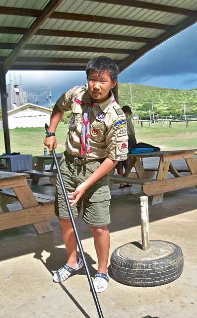 Scout Alex Wang helps clean the shelter at camp.