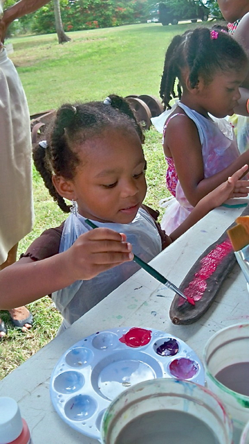 Ichone Belle, age 2, paints a flamboyant pod during Old Time Family Day Sunday at the Whim Museum.