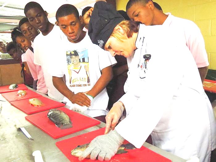 Chartwells chef Jennifer Brower teaches Kean High School students how to fillet tilapia (James Gardner photo).