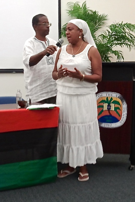 Moderator Stephen Isaac holds the microphone for Felicia Blake during her libation ceremony.