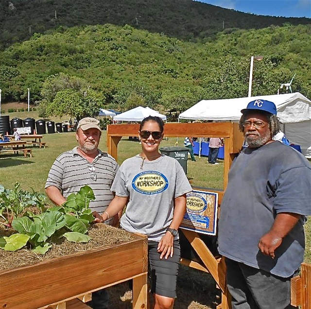 My Brother's Workshop founder Scott Bradley, left, and administrator Chistine Luton and UVI's Albion George with their produce planters.