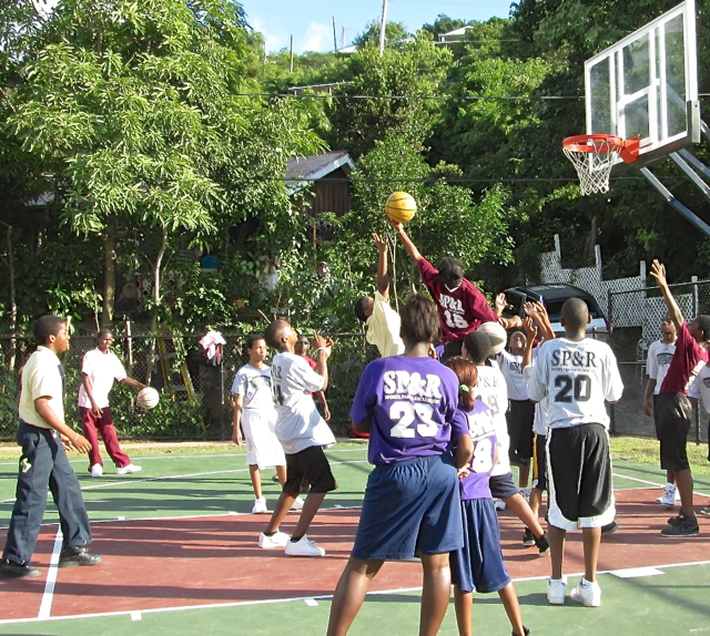Youths shoot hoops on the newly refurbished Pine Peace basketball court.