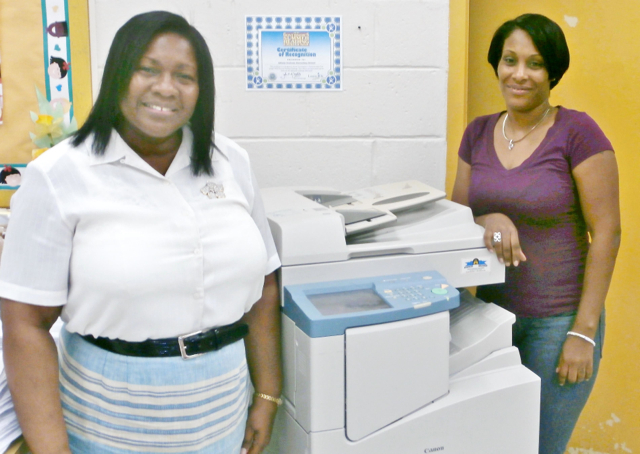 Alfredo Andres assistant principal Anna Marie Gordon, left, and secretary Sherika Milligan, with the donated copier. (Photo provided by the Rev. Rod Koopmans)
