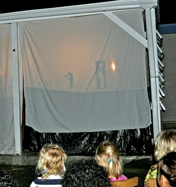 Students watch a shadow-puppet presentation of the story of St. Martin.