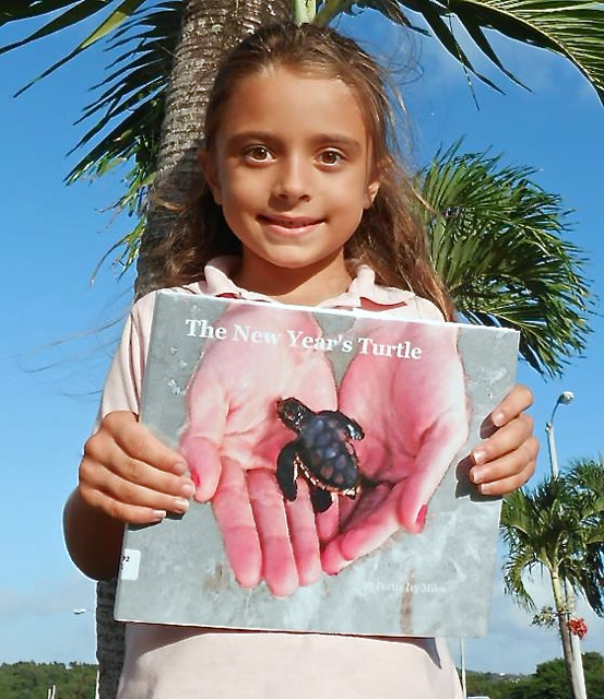 Portia Ivy Miles with a copy of her book, 'The New Year's Turtle.'