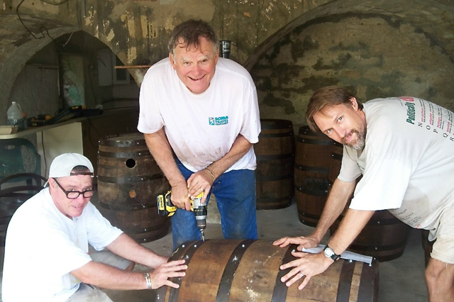 From left, Gary McCracken, Steve Grimes and Michael Dance refit a rum barrel.