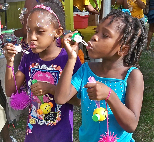 Naylanie Tejaba, 5, left, and Briana James, 6, blow bubbles at the VI-PR Cultural Exchange.