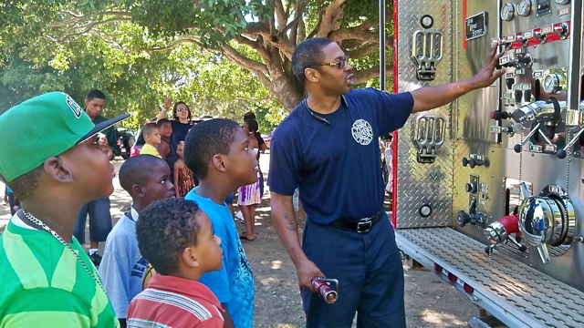 Firefighter George Otto shows kids the gauges and dials on the fire engine.