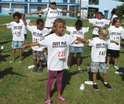 Youths in the ages seven and eight age group warm up at Just Play Day.