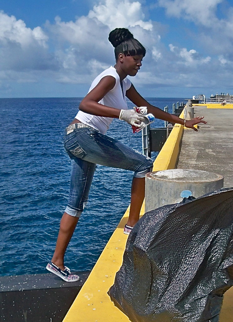 Briana Eugene, a junior at Complex, picks up trash on the pier at Frederiksted.