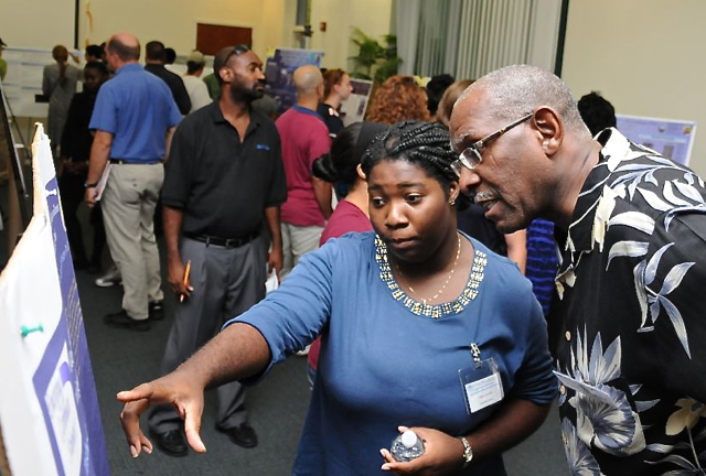 Student Tasha Corneille explains tick DNA recovery to UVI president David Hall. (Photo Gary Metz)