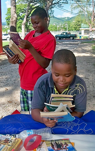 Kevin Manon, 9, in front, and Roosdert Manon, 12, are happy with their free books.