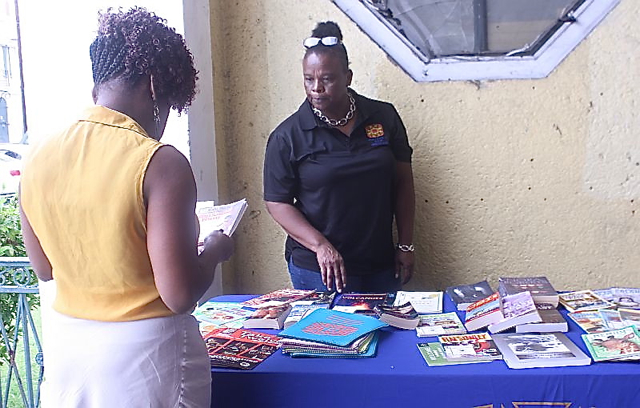 WTJX's Cheryl Liburd hands out books to community members in celebration of International Literacy Day.