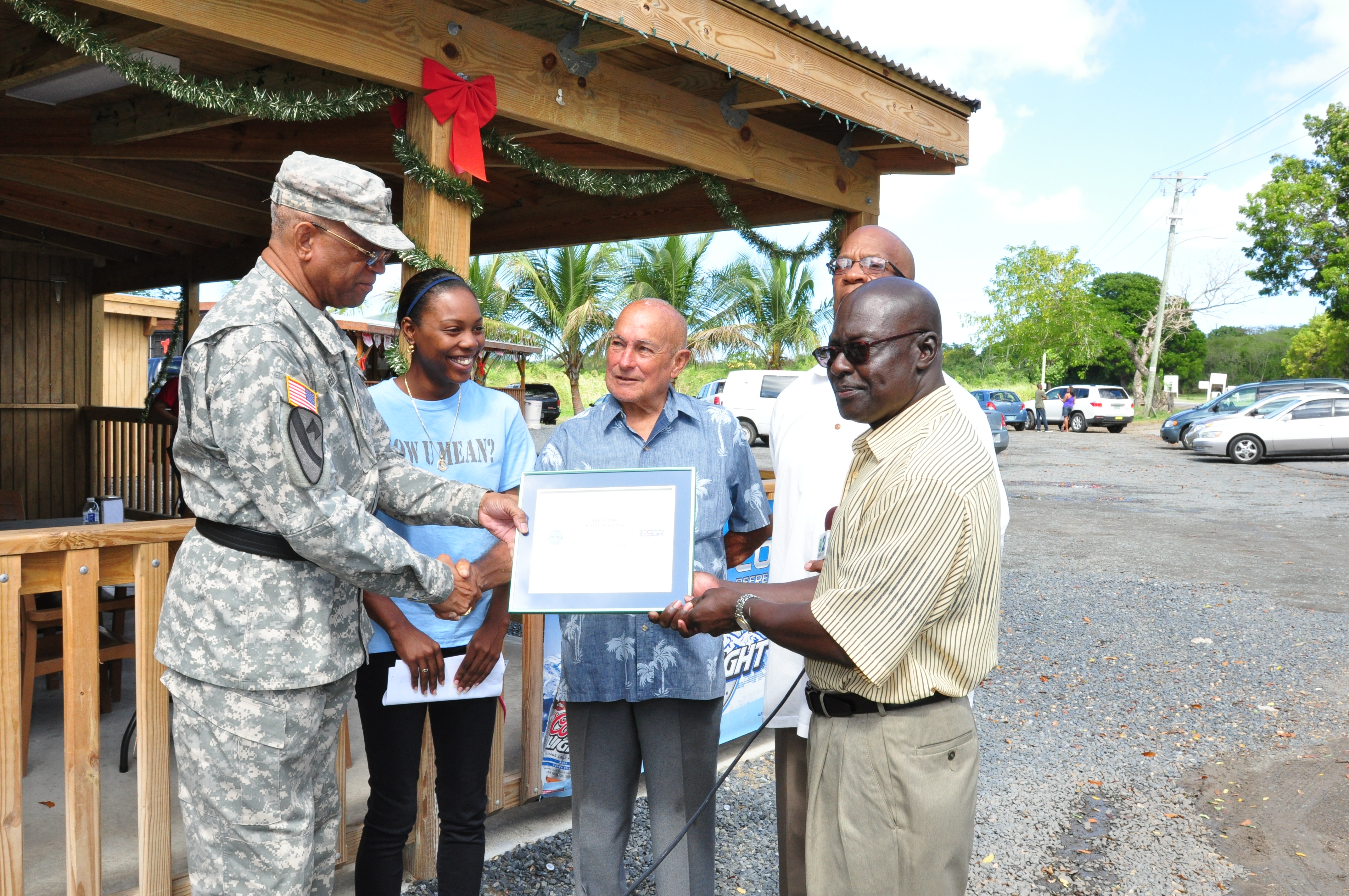 Maj. Gen. Renaldo Rivera, adjutant general of the Virgin Islands National Guard, left, Lt. Col. (Ret.) Beresford Edwards, Employer Support of Guard and Reserve (ESGR) chair, right, and Mr. Paul Radix, ESGR manager of employer outreach, second from right, present Mr. Angel Diaz with the DoD Patriot Award Friday at La Reine Chicken Shack. Diaz, owner of La Reine Chicken Shack was nominated by Spc. Felicia Herman (second from left) for his outstanding support of her as an employee and as she fulfills her commitments to the VING. (VING photo by Sgt. Juanita Philip-Mathurin).	