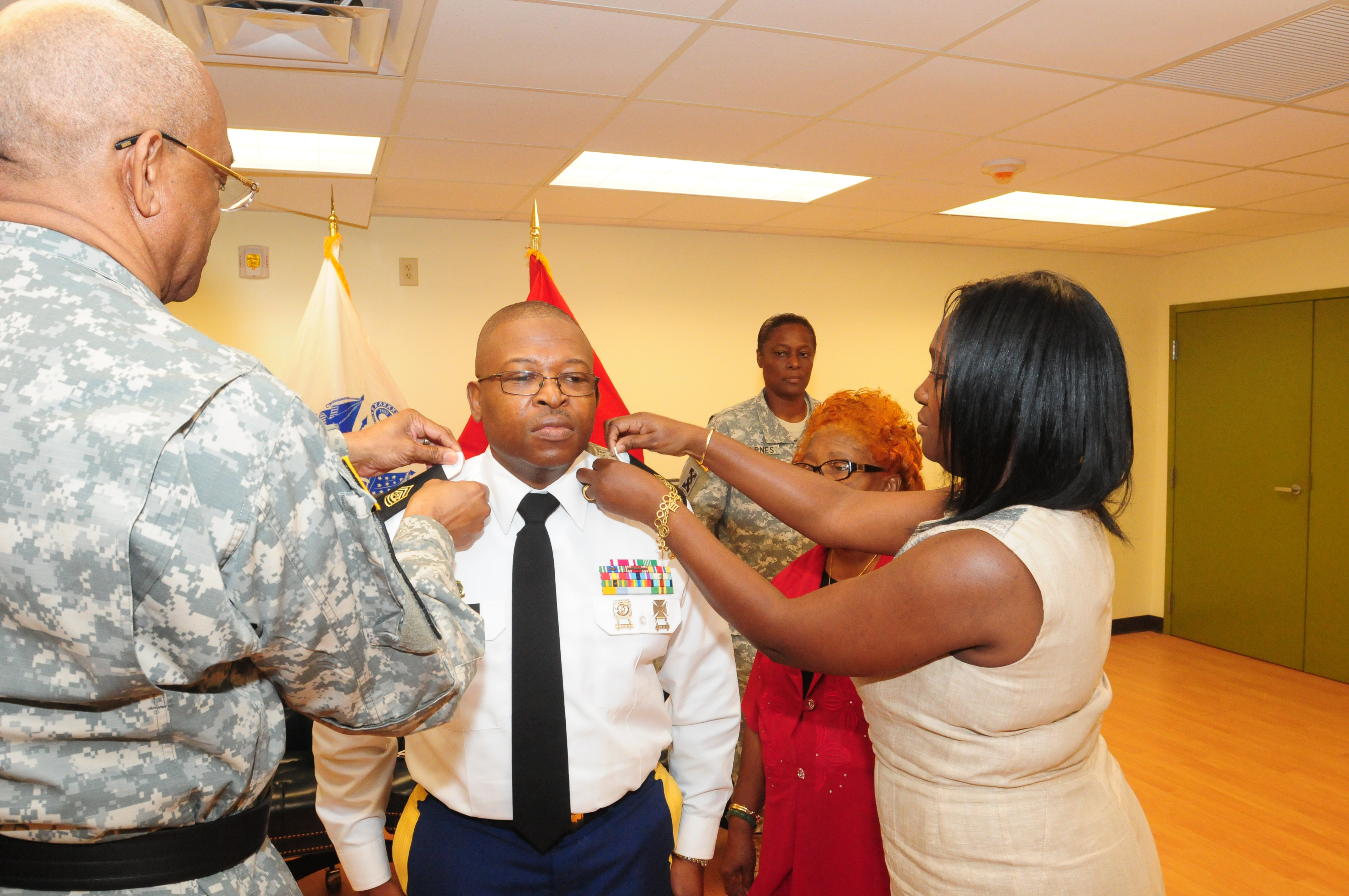 1st Sgt. Eugene Farrell is promoted to the rank of sergeant major and is pinned by Maj. Gen. Renaldo Rivera, adjutant general of the Virgin Islands, and his wife, Wean, as his mother, Mildred Hodge,  looks on during a promotion ceremony Jan. 12. Farrell was also appointed as the command sergeant major of the Virgin Islands National Guard 786th Combat Sustainment Support Battalion in St. Thomas during the ceremony. (VING photo by Sgt. Juanita Philip-Mathurin).	