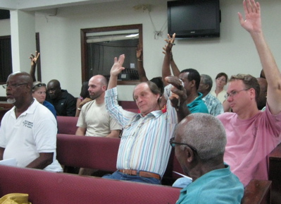 Rental car company representatives raise their hands to support an increase in the quota.