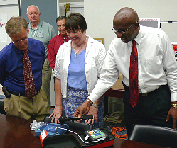 Peter Dybing (left to right), Will Cher and St. Croix Administrator Dodson James with one of the new defibrillators.