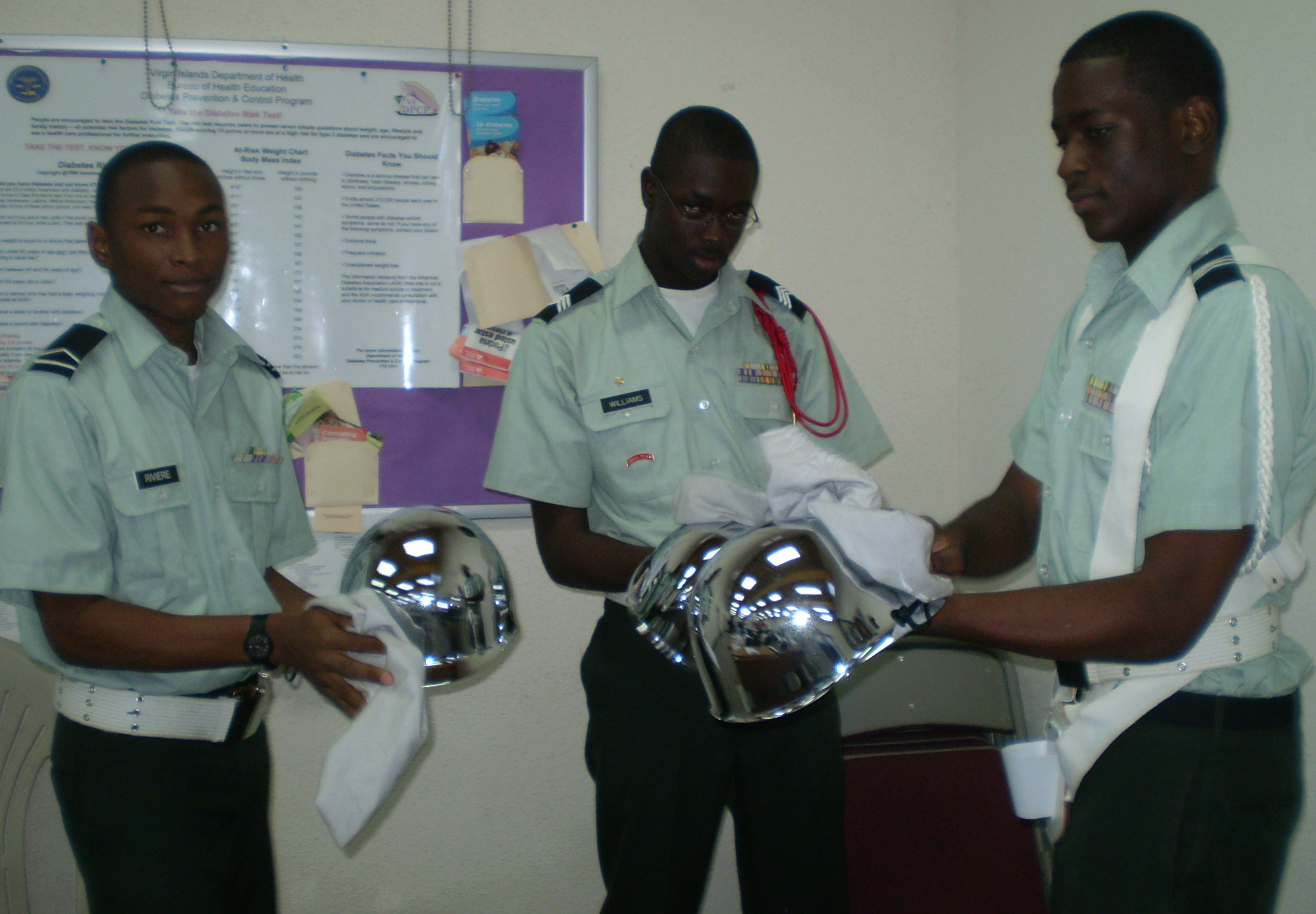 ROTC cadets Johnny Rivere (left), Delvin Williams, and Terrance James shining helmets.