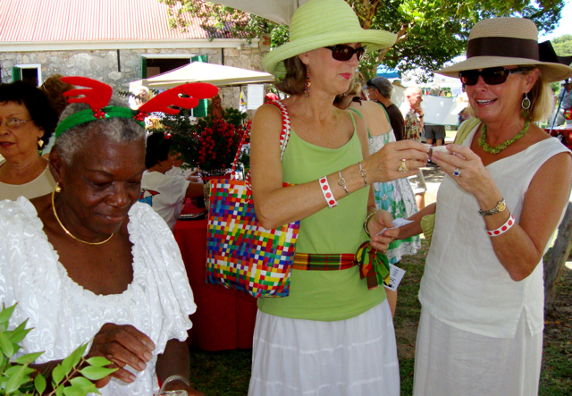 Nancy Gentry, in green, and Bonnie Baker make a toast with the guavaberry liqueur made by Shirley Govine, left.