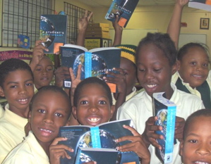 Excited third-grade students from Jane E. Tuitt Elementary display their new dictionaries.