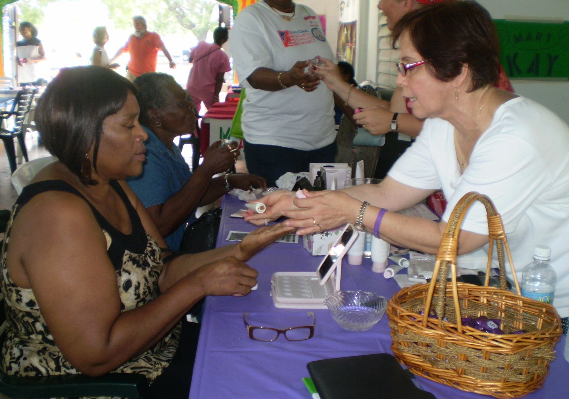 Fran Joseph (left) gets makeup tips from Millie Chaparro, beauty consultant.